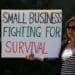 A small business owner with a sign explaining her troubles during the Covid-19 pandemic. Photo by Gene Gallin/Unsplash