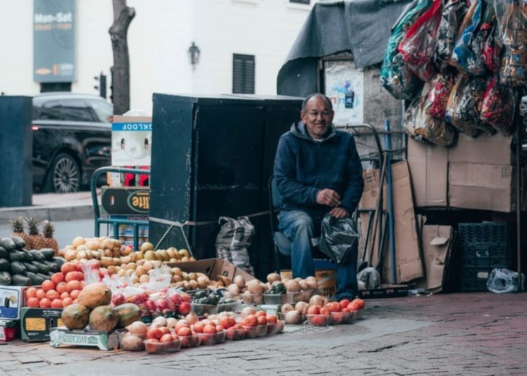 A informal trader sells fruit and vegetables on a street corner. Picture by Leo Moko/Unsplash