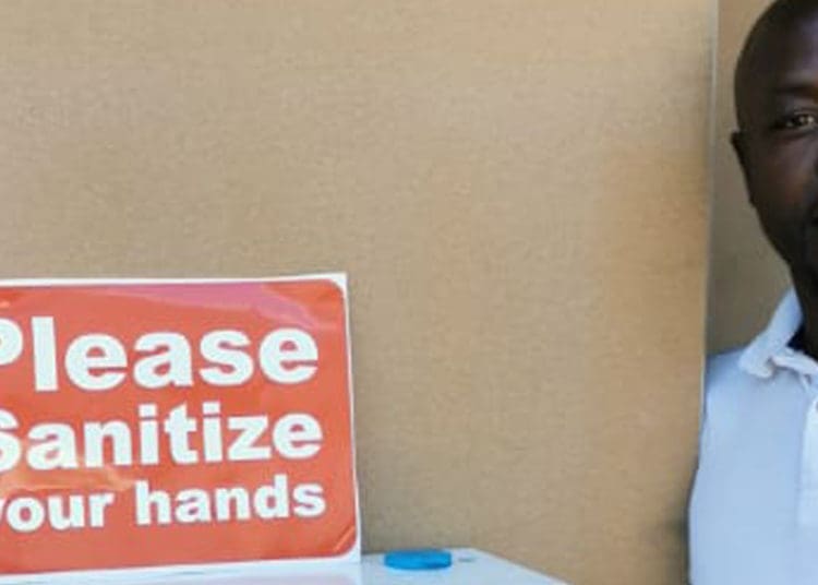 Ezekiel Moimane stands next to the automatic sanitising machine that he designed