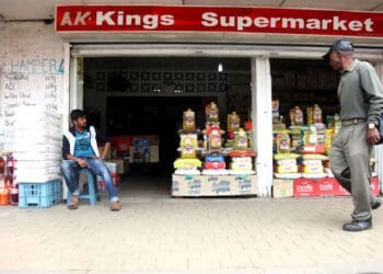 A spaza owner sits outside his supermarket in Kliptown, Soweto. Photo: Nhlanhla Phillips